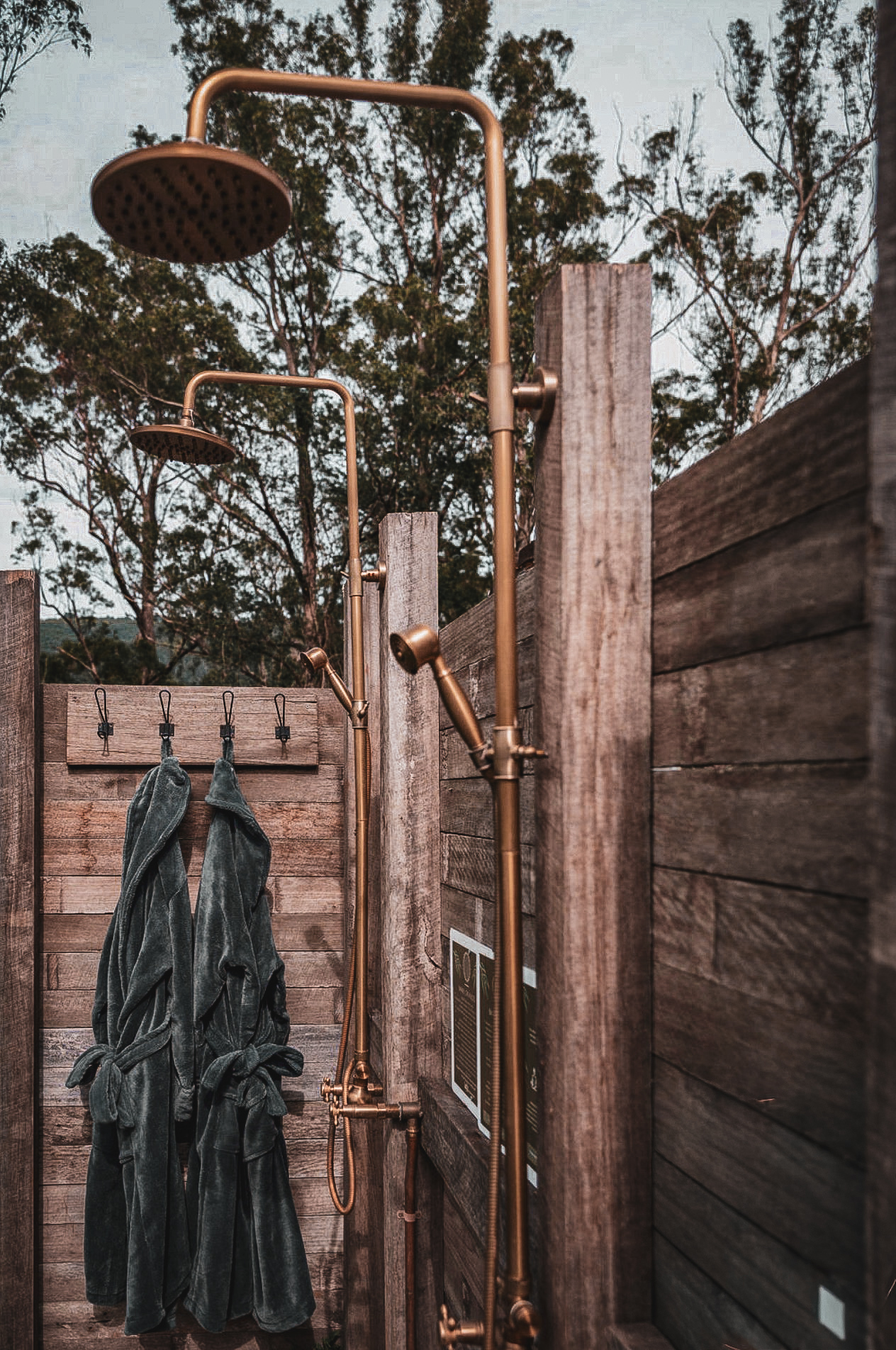 The outdoor twin rain showers with robes hanging ready
